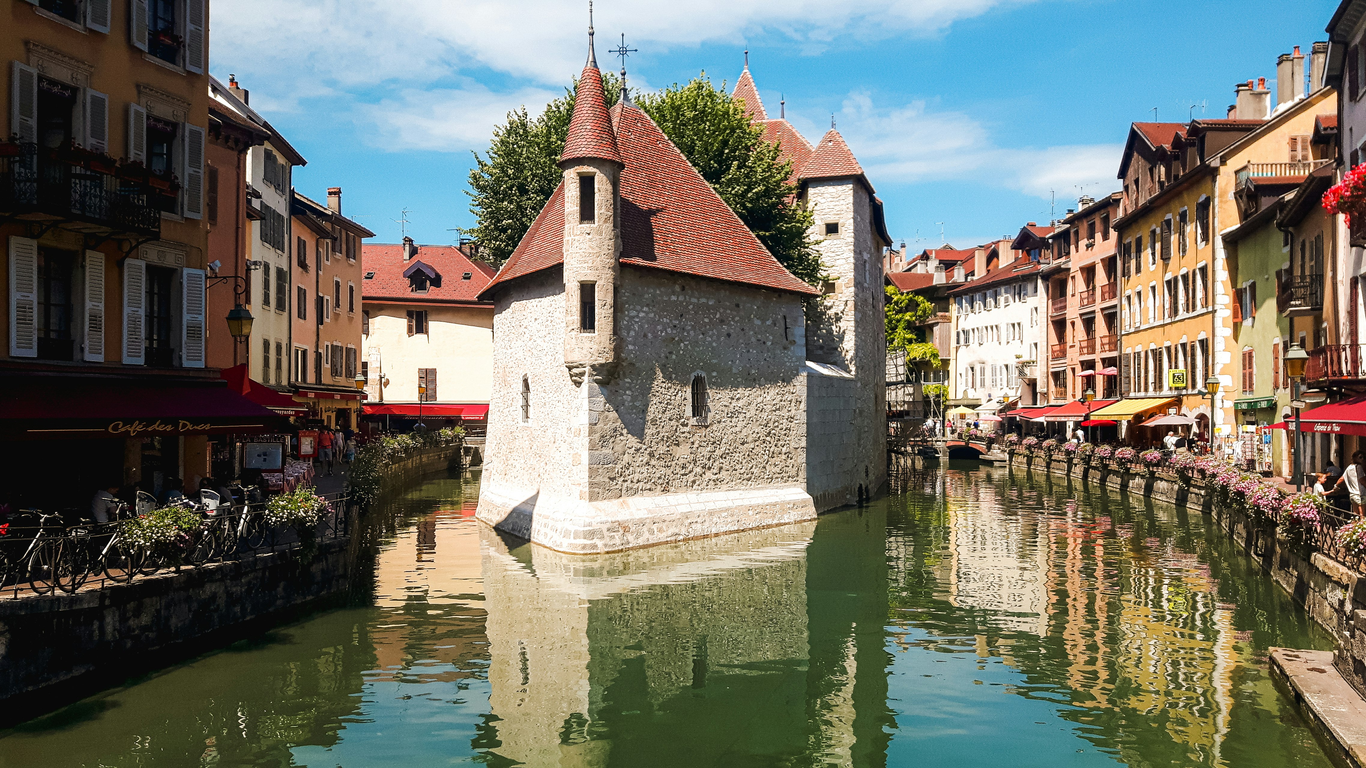 white and brown concrete building beside river under blue sky during daytime